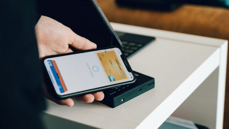 Persona gestionando pagos y transferencias con una billetera digital desde un celular