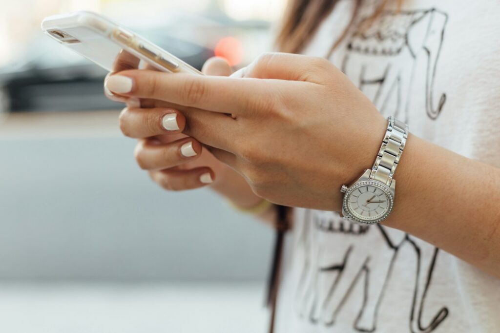 Mujer revisando y respondiendo mensajes en una red social desde un teléfono celular