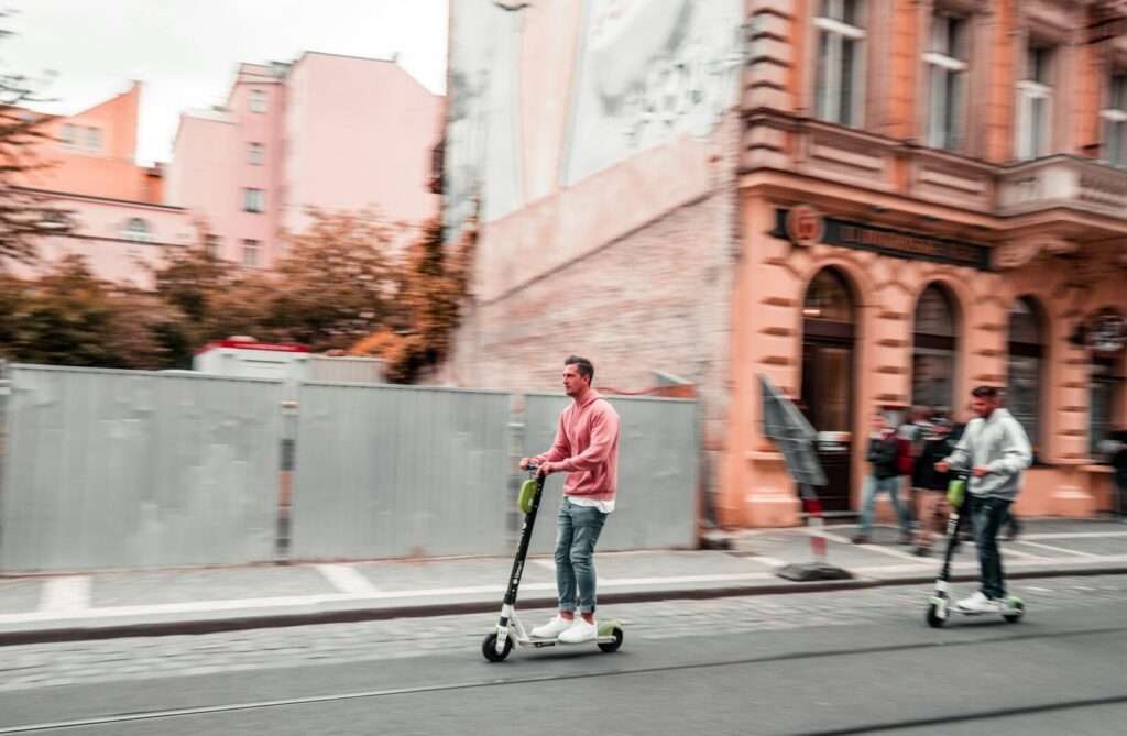 Persona circulando en una patineta eléctrica por una vía de ciudad