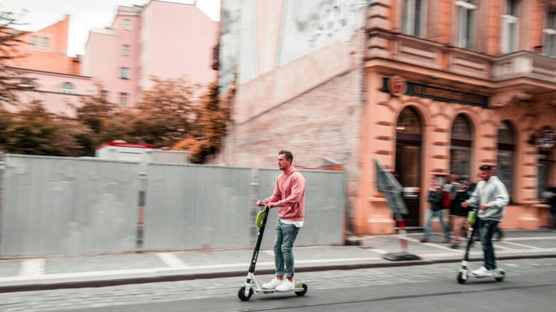 Persona circulando en una patineta eléctrica por una vía de ciudad