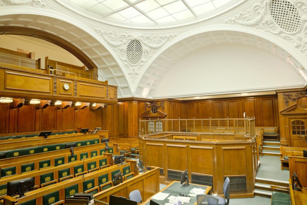 Balanza y mazos en una sala judicial, símbolo del proceso penal que adelanta la Fiscalía tras la denuncia contra un creador de contenido