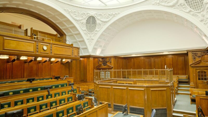 Balanza y mazos en una sala judicial, símbolo del proceso penal que adelanta la Fiscalía tras la denuncia contra un creador de contenido