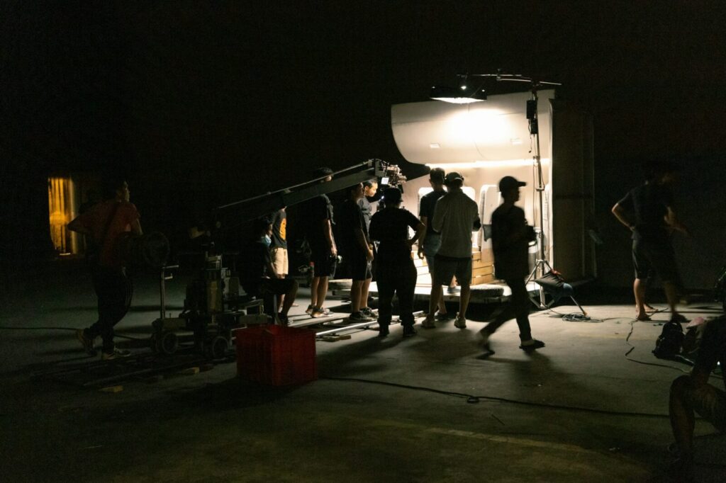 Set de filmación con equipo de producción y cámara de cine durante el rodaje de una obra audiovisual