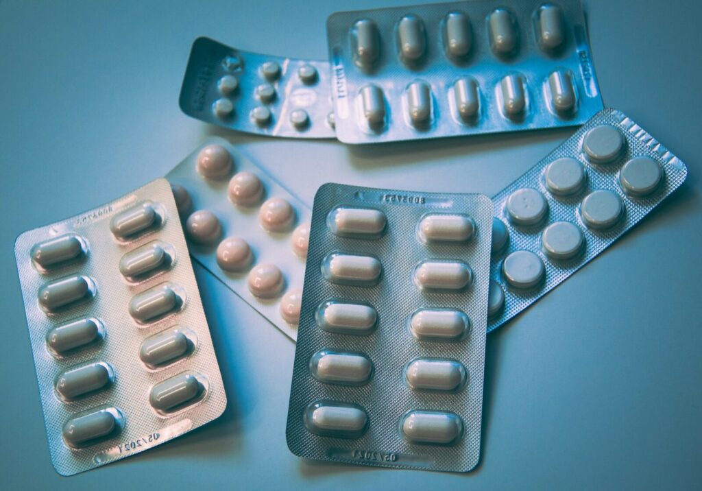 Cajas y frascos de medicamentos en una farmacia, ilustración de la nota sobre los trámites del Invima.