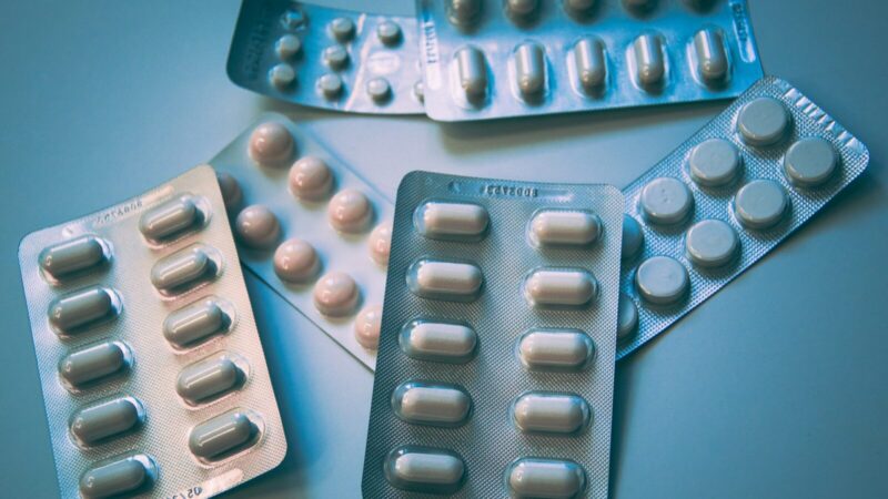 Cajas y frascos de medicamentos en una farmacia, ilustración de la nota sobre los trámites del Invima.