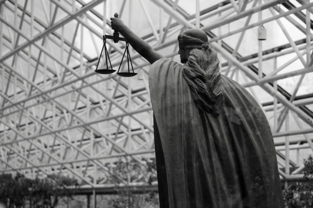 Sala de un juzgado con la balanza de la justicia en primer plano