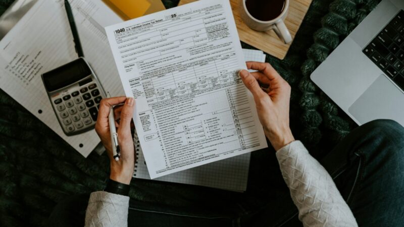 Documentos tributarios junto a una calculadora y elementos de oficina
