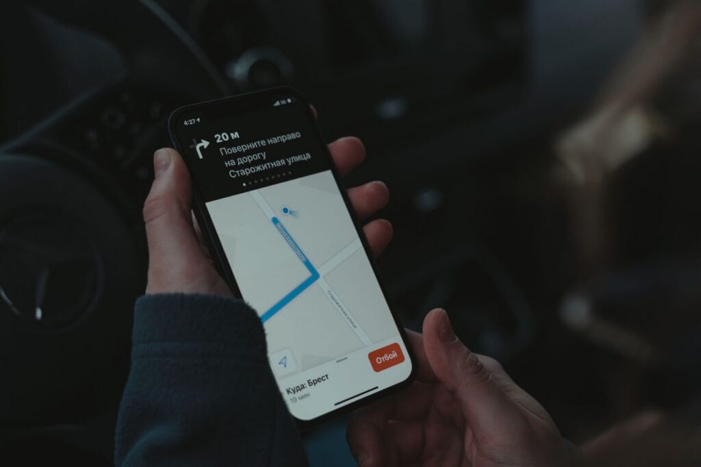Persona sosteniendo un smartphone con una aplicación de localización de dispositivos en pantalla