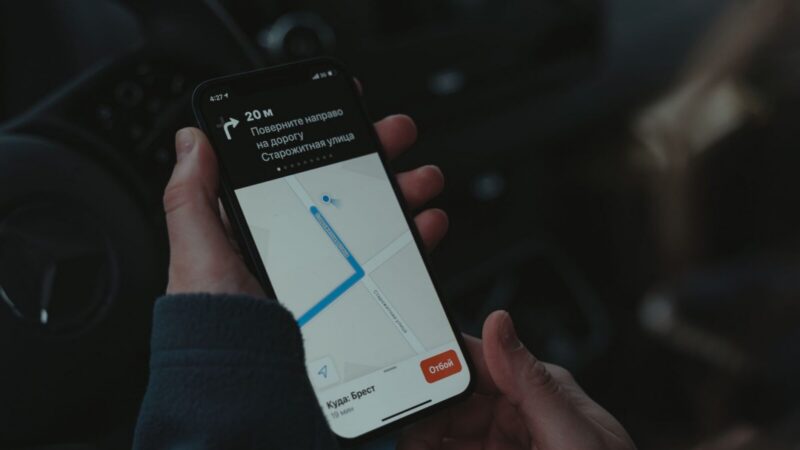 Persona sosteniendo un smartphone con una aplicación de localización de dispositivos en pantalla