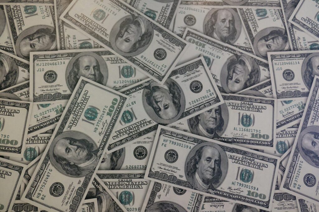 Billetes de dólar junto a monedas que representan el comportamiento del mercado cambiario