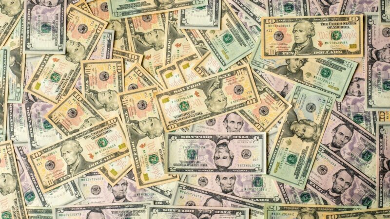 Billetes de dólar y monedas representan el comportamiento del mercado cambiario