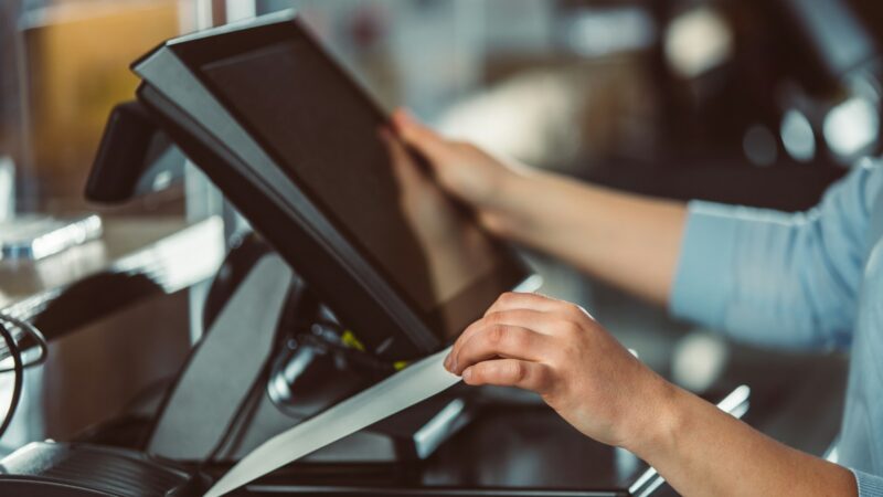 Cliente realiza una operación financiera en la caja de una tienda o supermercado