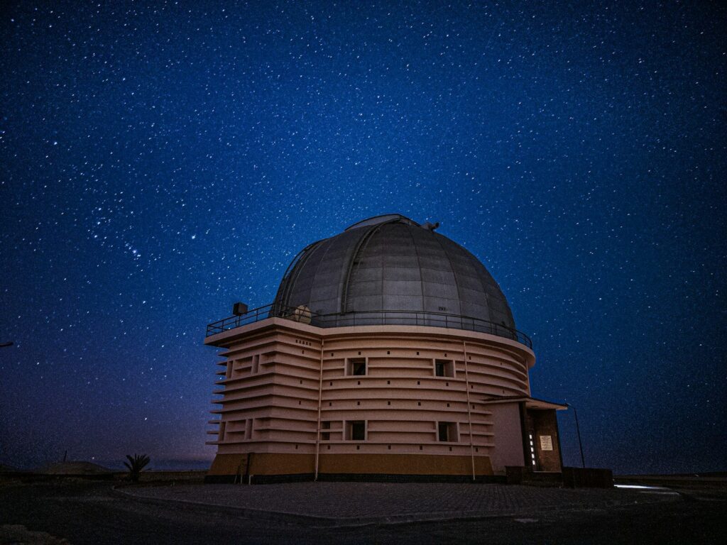 Telescopio de un observatorio apuntando hacia el cielo nocturno