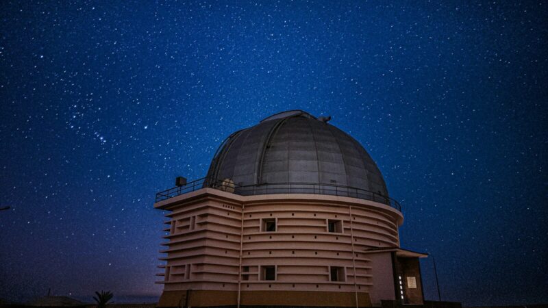 Telescopio de un observatorio apuntando hacia el cielo nocturno