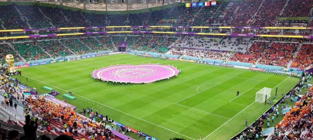 Jugadores disputan un partido de fútbol ante las tribunas de un estadio