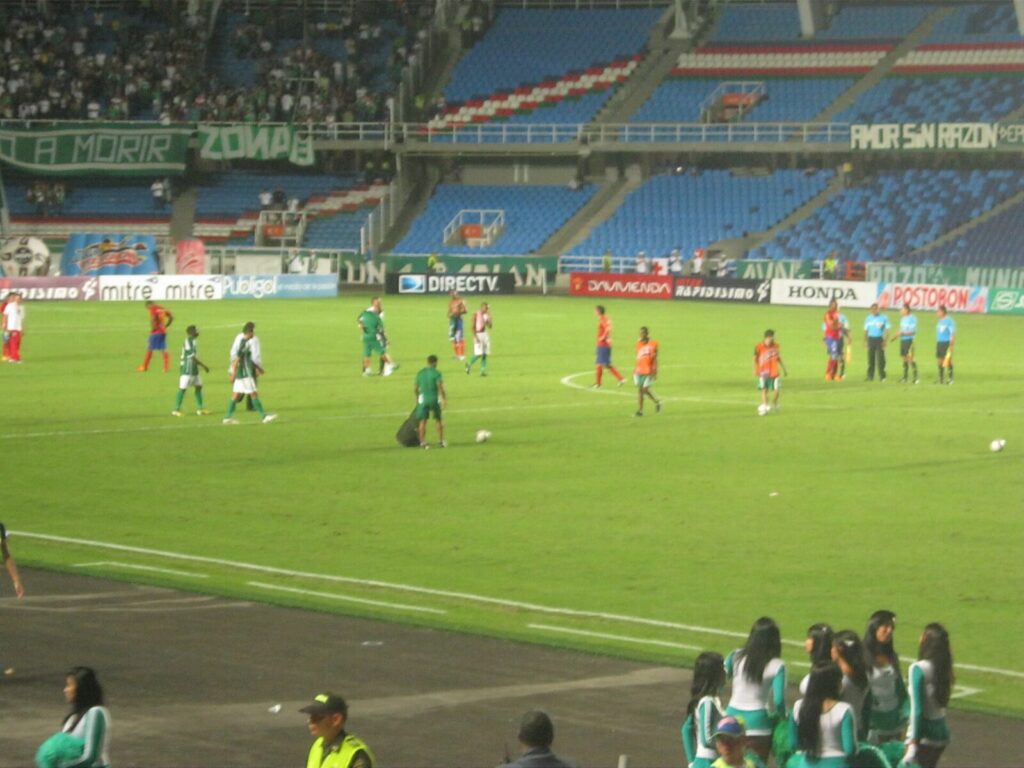 Entrenador de fútbol dirigiendo una sesión en un estadio