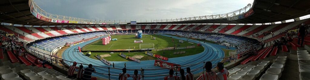 Vista exterior de un estadio de fútbol iluminado durante la noche, en referencia al renovado Metropolitano de Barranquilla