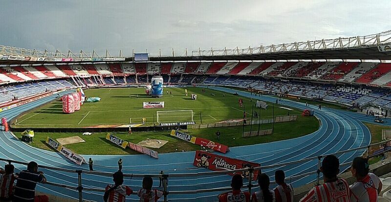 Vista exterior de un estadio de fútbol iluminado durante la noche, en referencia al renovado Metropolitano de Barranquilla