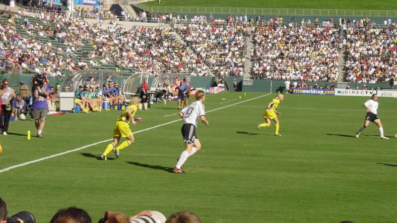 Jugadoras disputan un partido de fútbol femenino ante las tribunas de un estadio