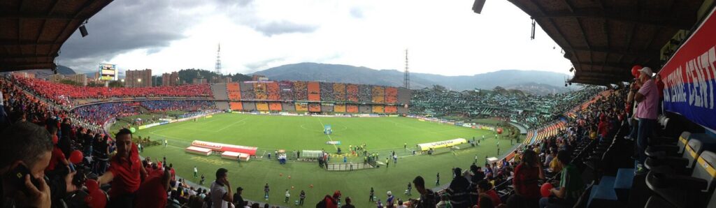 Estadio de fútbol con aficionados durante un partido del fútbol colombiano
