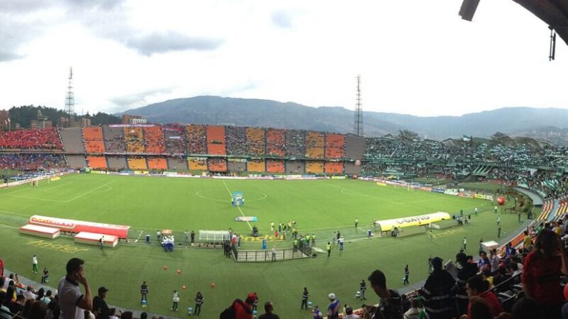 Estadio de fútbol con aficionados durante un partido del fútbol colombiano