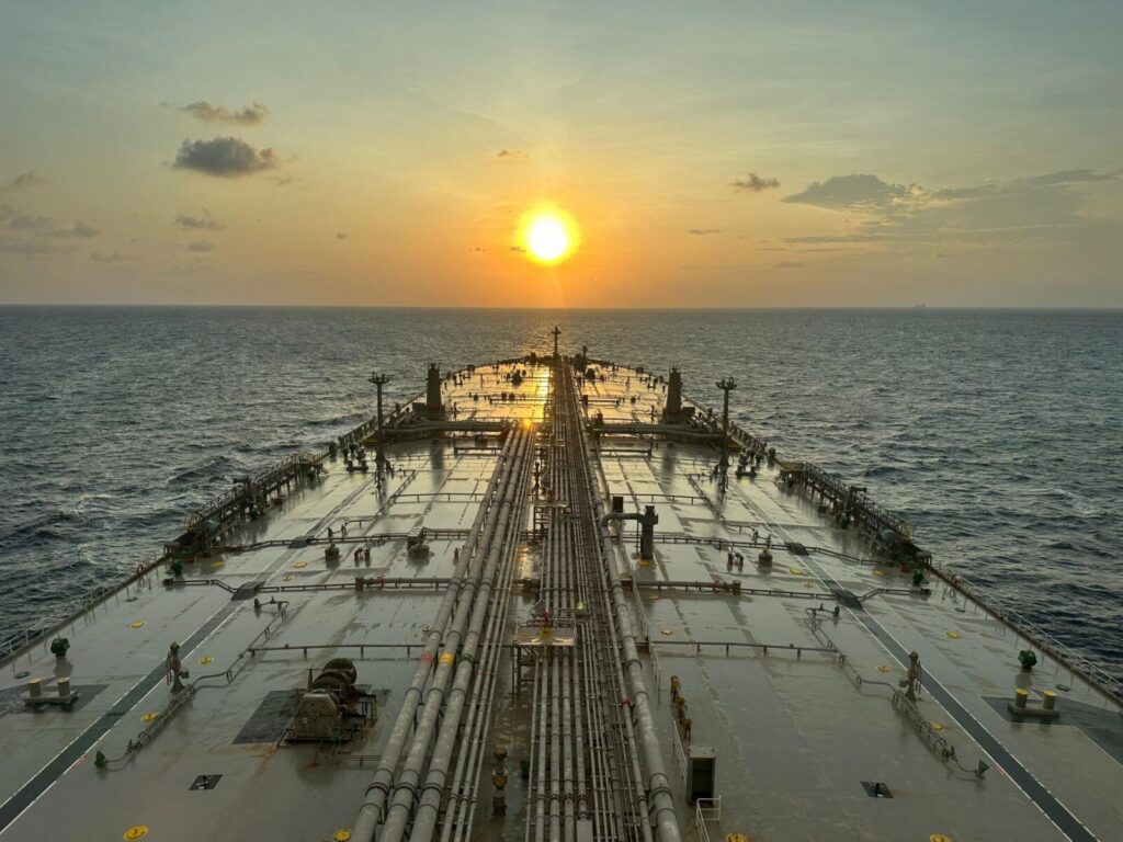 Barriles de petróleo y un buque cisterna en una escena relacionada con el mercado energético