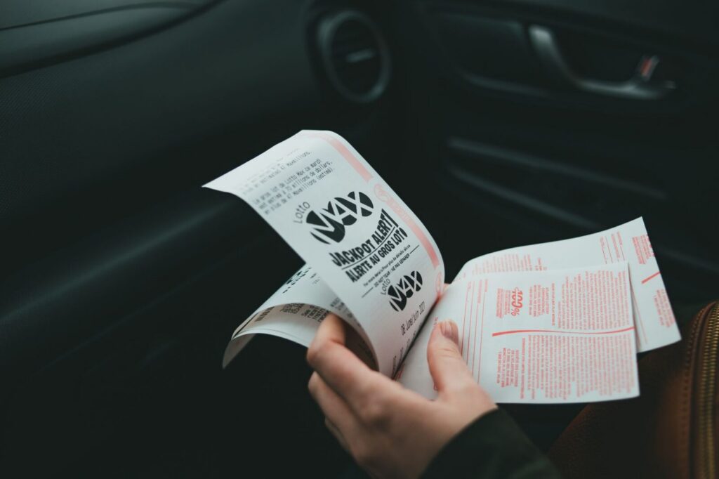 Boletos y números de lotería sobre una mesa, asociados con un sorteo y sus acumulados