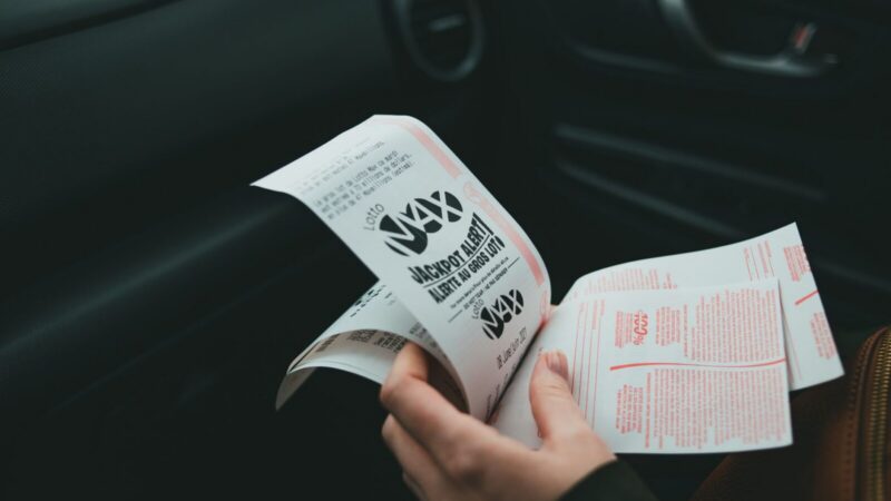 Boletos y números de lotería sobre una mesa, asociados con un sorteo y sus acumulados