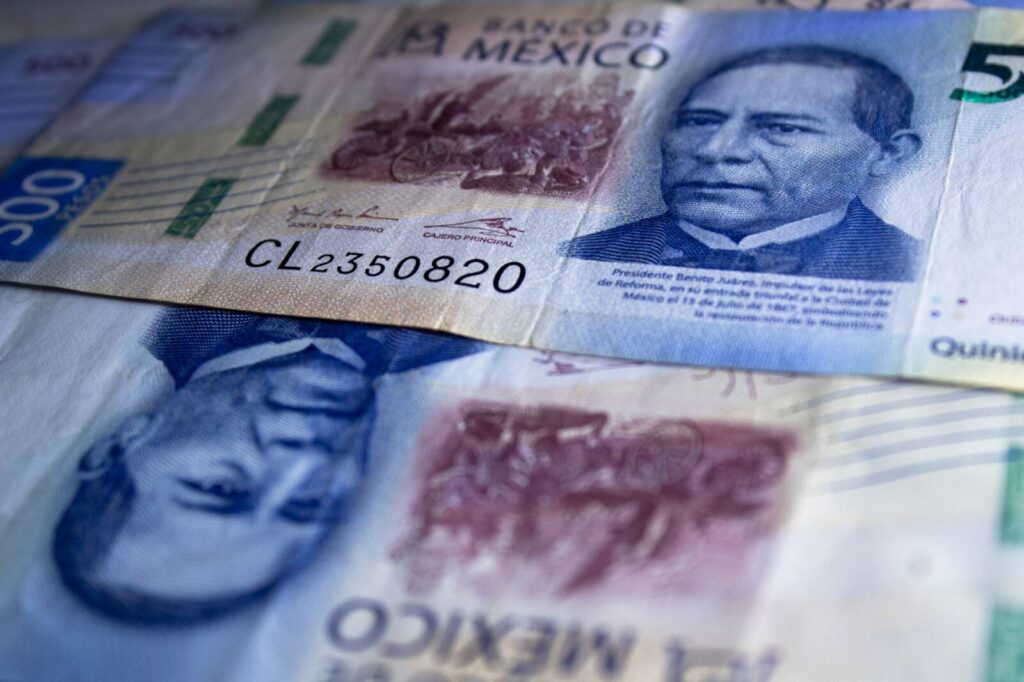 Billetes del peso colombiano dispuestos sobre una superficie, referente del costo de vida en el país