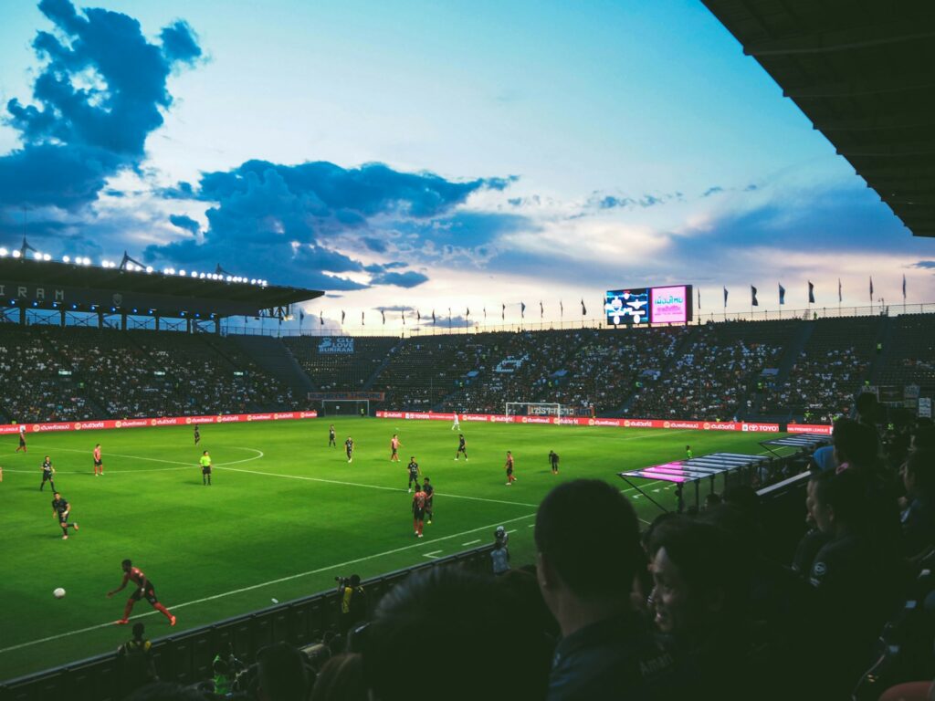 Jugadores disputan un partido de fútbol en un estadio durante una jornada deportiva con propósito solidario