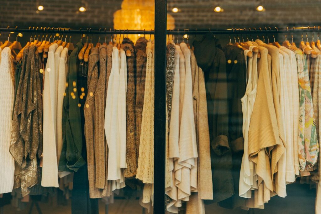 Ropa organizada en los exhibidores de una tienda de moda