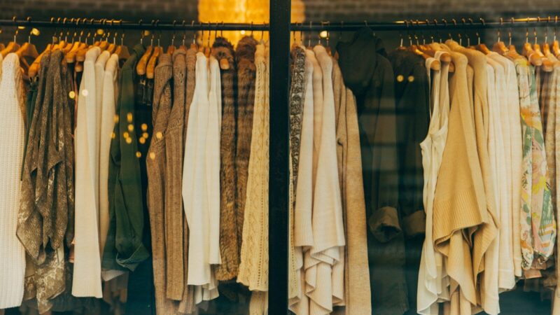 Ropa organizada en los exhibidores de una tienda de moda