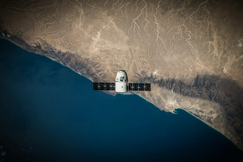 Representación de un satélite observando contaminantes y humo sobre la atmósfera terrestre