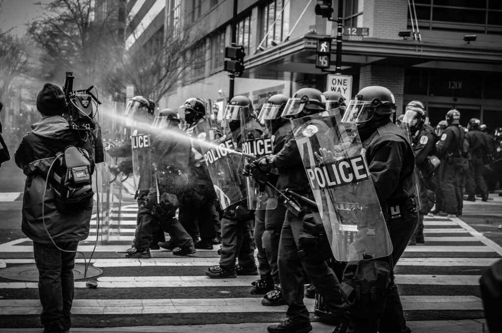 Manifestantes participan en una movilización mientras agentes de la Fuerza Pública permanecen en los alrededores.