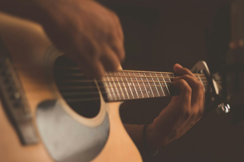 Cantautor con guitarra durante una presentación musical de carácter cultural
