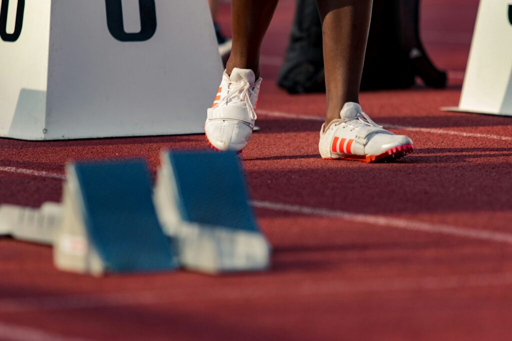 Atletas compiten en una carrera de relevos sobre una pista de atletismo
