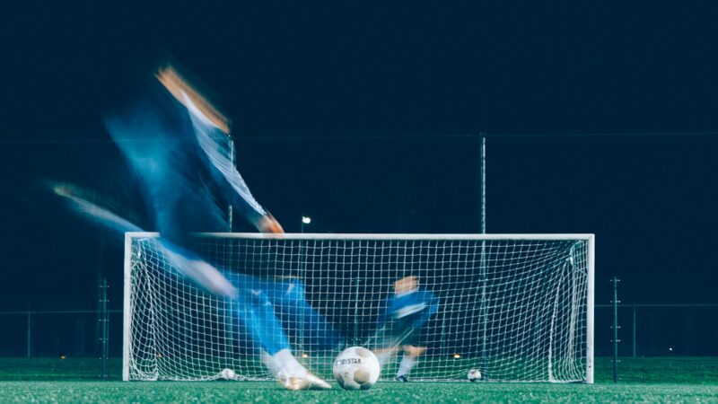 Jugadores disputando un partido de fútbol en un estadio ante los aficionados