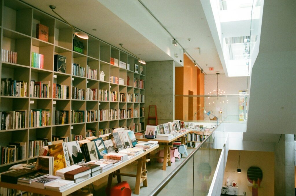 Estanterías de madera con libros y cuadernos en el interior de una pequeña librería en Tokio