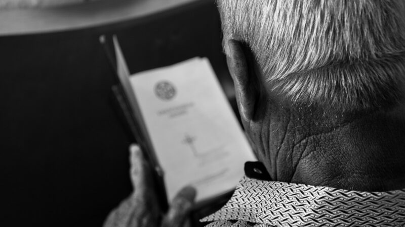 Persona mayor revisando documentos, en referencia al trámite de la pensión por invalidez