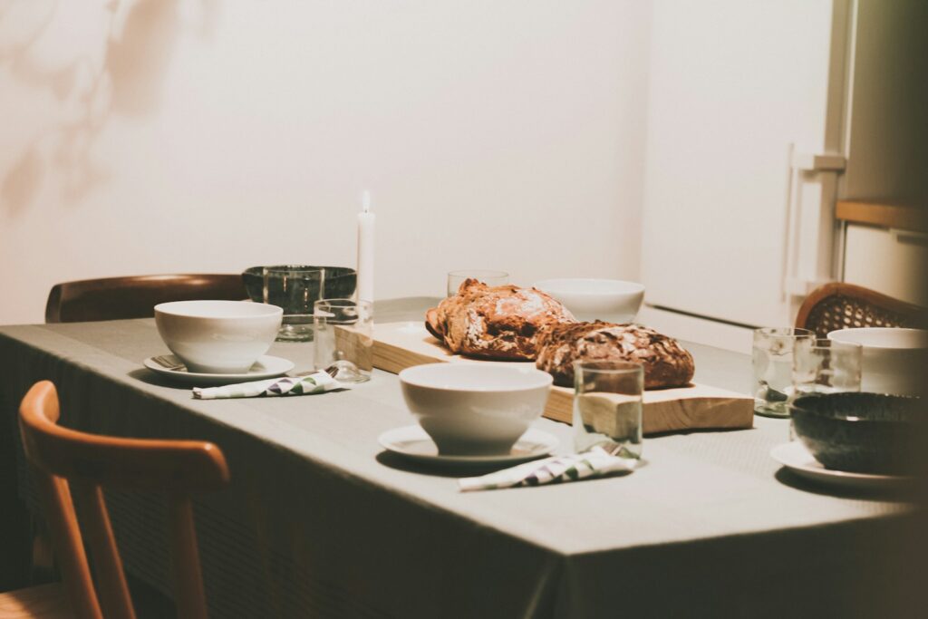 Mesa de comedor con mantel y vajilla listos para una comida familiar, elementos centrales del Feng Shui para la prosperidad del hogar.