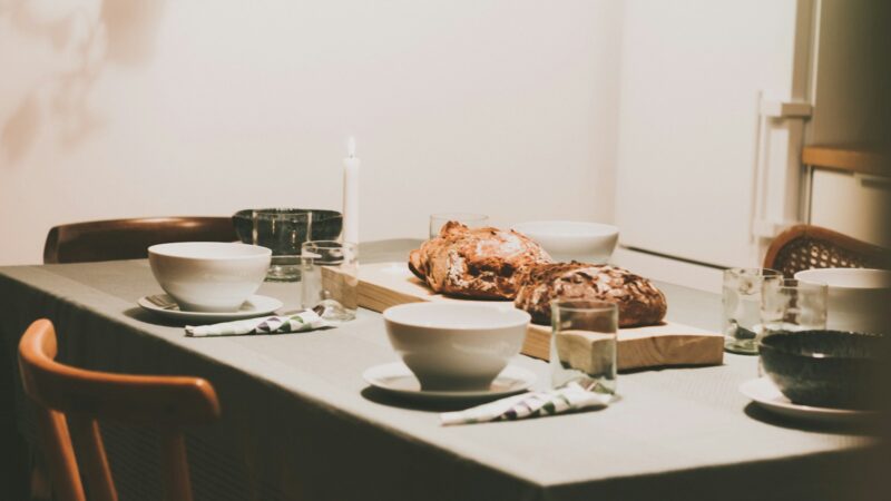 Mesa de comedor con mantel y vajilla listos para una comida familiar, elementos centrales del Feng Shui para la prosperidad del hogar.