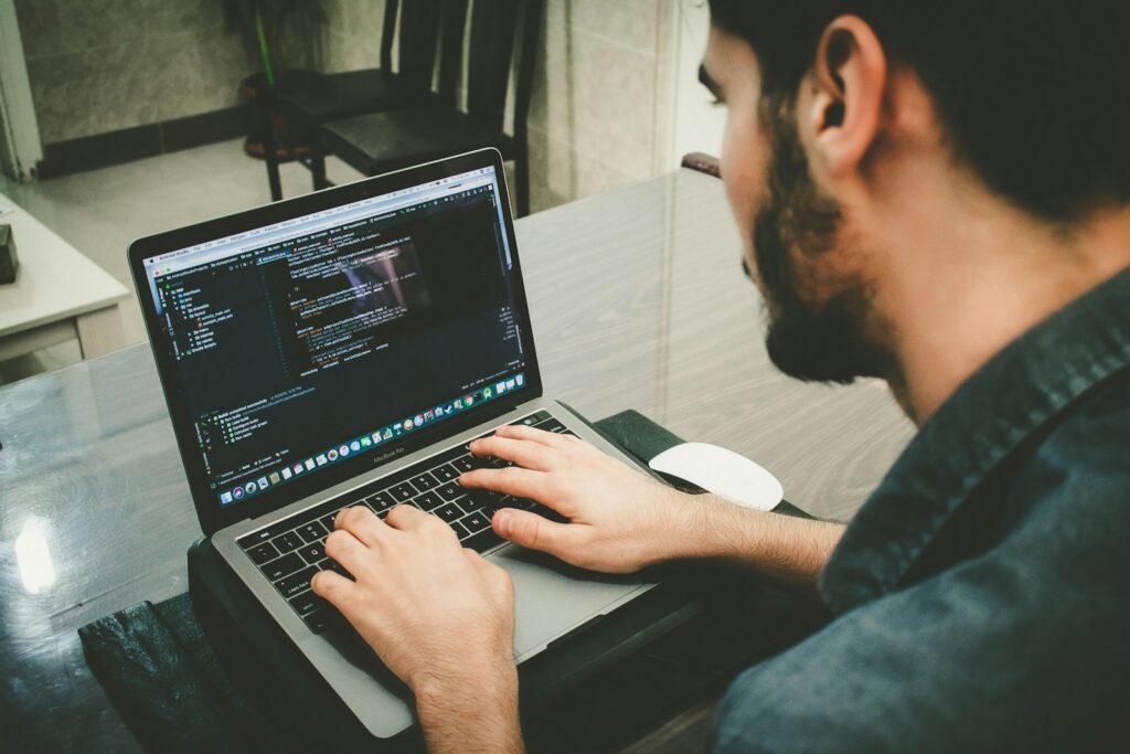 Persona aprendiendo programación con apoyo de herramientas de inteligencia artificial en un computador