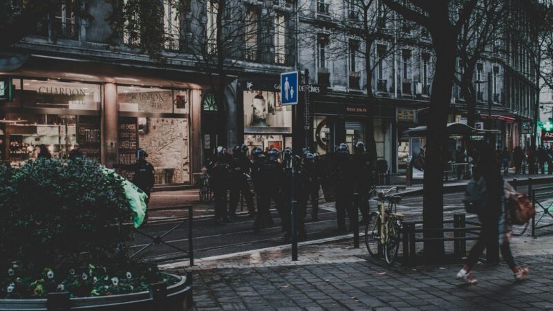 Fuerzas de seguridad vigilan una calle urbana durante protestas y disturbios en Francia