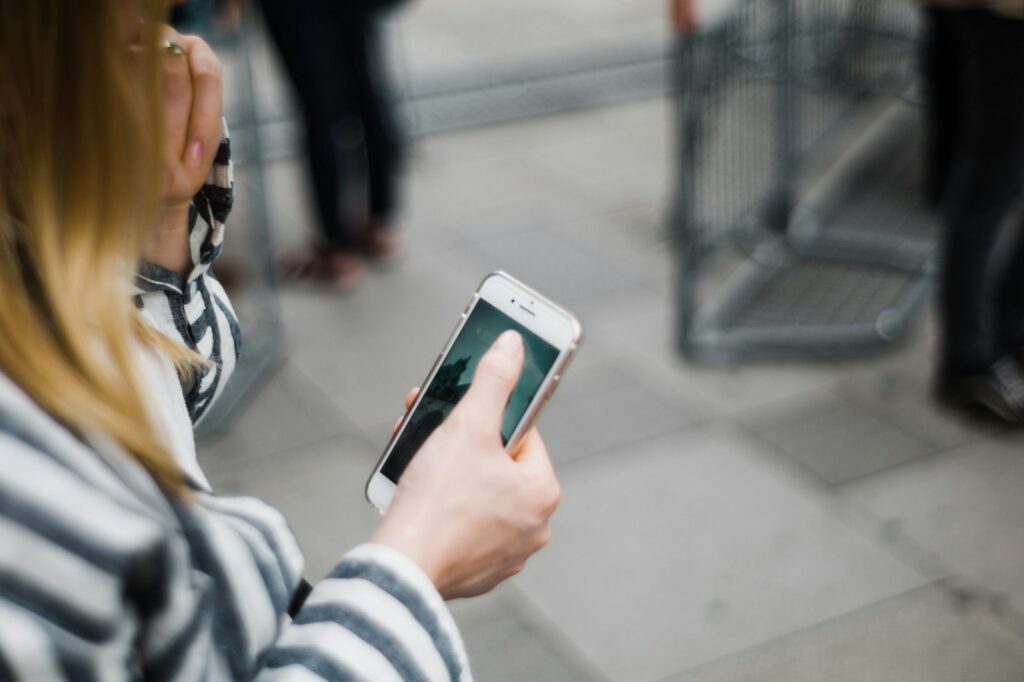 Persona sosteniendo un teléfono inteligente, símbolo del riesgo de programas espía que acceden a la cámara móvil