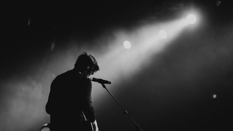 Músico interpretando canciones en vivo frente al público durante un concierto