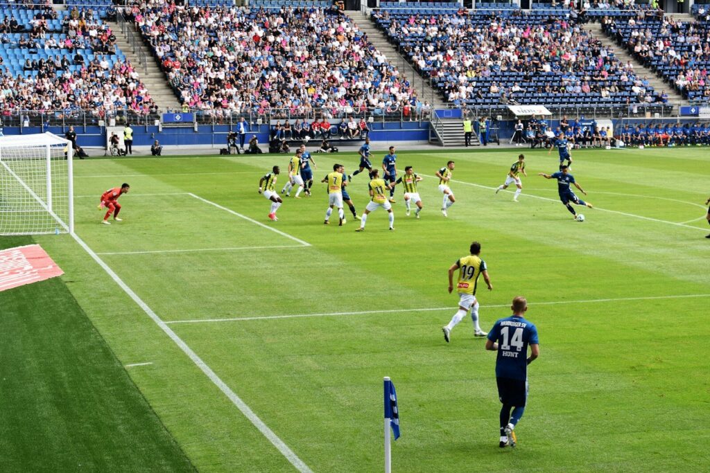 Jugadores disputan un partido de fútbol en un estadio, en referencia al cruce entre Millonarios y Barranquilla FC