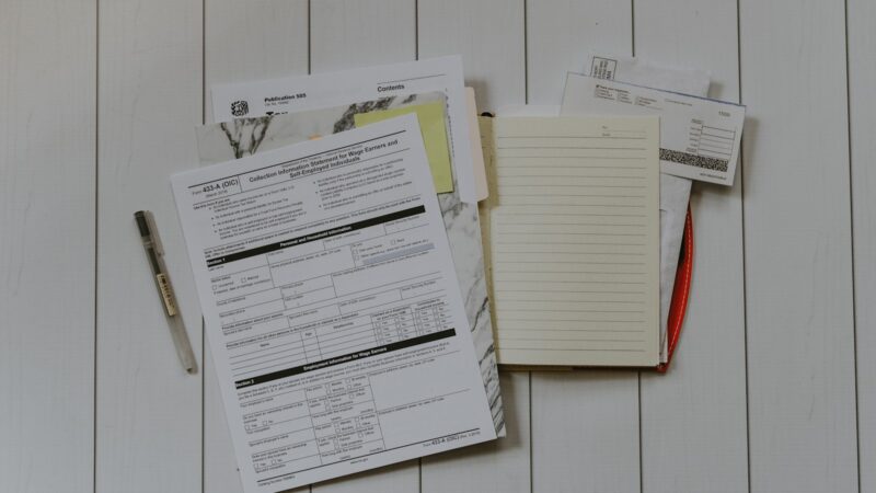 Persona revisando documentos y cálculos relacionados con su pensión y ahorro para la vejez