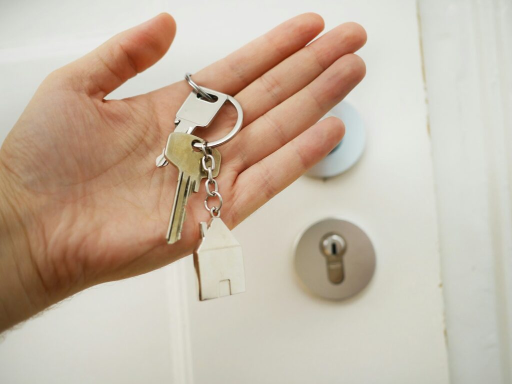 Llaves de una vivienda junto a elementos relacionados con ahorro y financiación