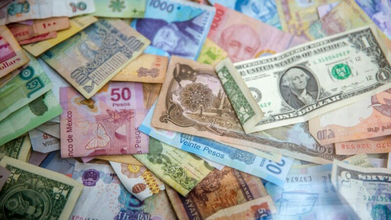 Persona realizando una transferencia internacional de dinero desde una cuenta bancaria