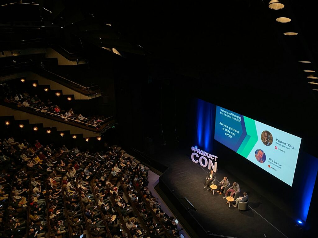 Auditorio durante un foro empresarial con conferencistas y asistentes
